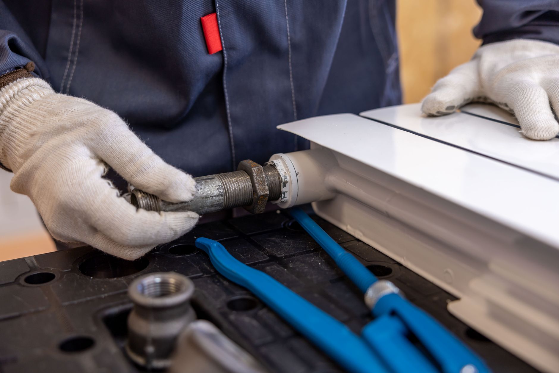Close-up of pipe fittings and tools during radiator pipe work