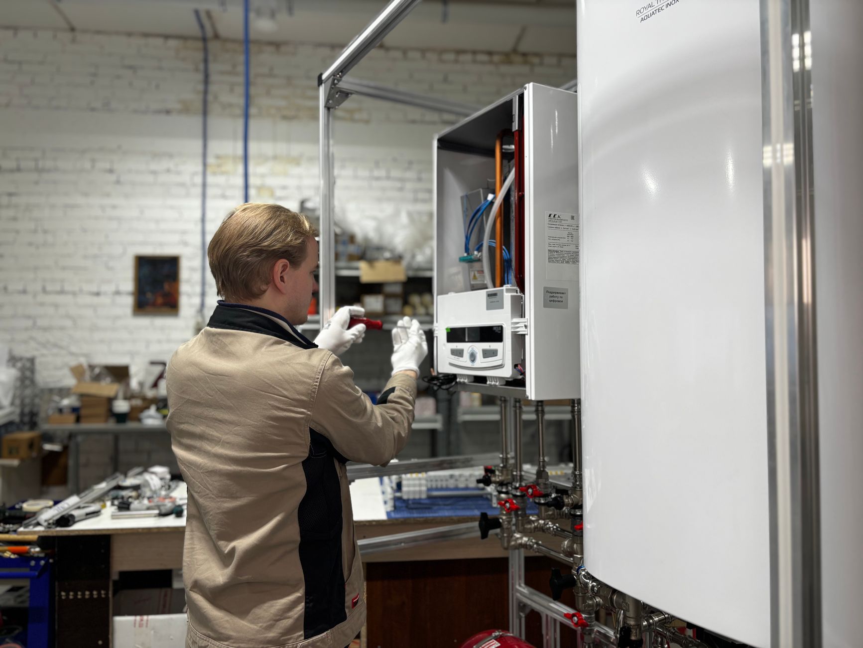 Technician checking controls on a wall mounted heating unit